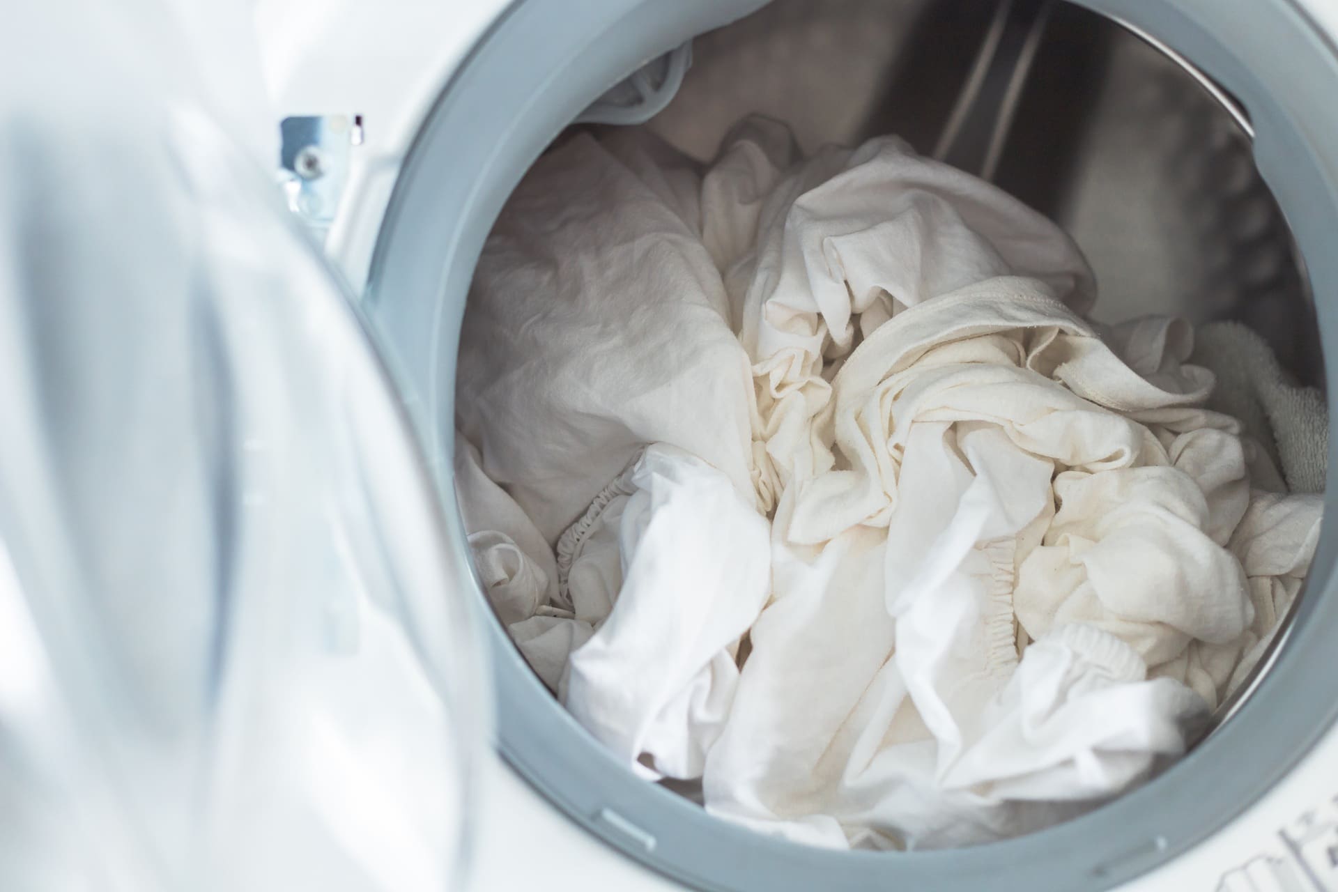 A close-up view of white laundry inside a front-loading washing machine.